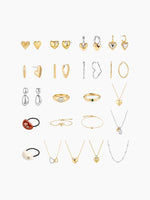 A flat-lay grid display of the earring assortment included in the kit, showing pairs of gold and silver earrings (studs, hoops, and drops) arranged neatly.
