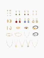 A flat-lay grid display of the earring assortment included in the kit, showing pairs of gold and silver earrings (studs, hoops, and drops) arranged neatly.