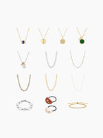 A flat-lay grid display of the necklace assortment included in the kit, featuring various gold and silver chain styles, pendants, and bracelets arranged vertically.