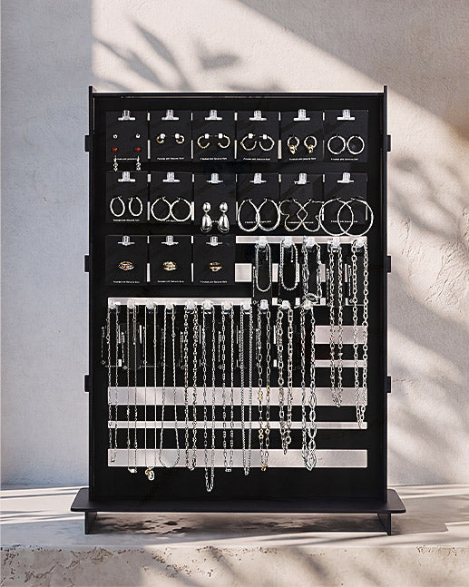 A black jewelry organizer stand filled with silver-toned jewelry