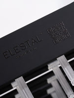 A macro close-up of the black wooden base featuring the engraved "ELESTAL" brand logo and text, showing the clear hooks inserted above.