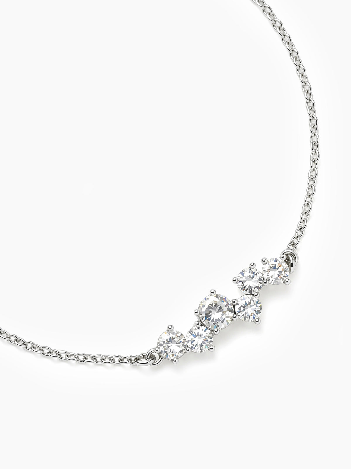 A close-up angled view of the silver CZ cluster chain bracelet curved on a white background, focusing on the detail of the central stones.
