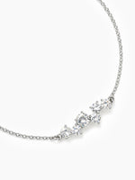 A close-up angled view of the silver CZ cluster chain bracelet curved on a white background, focusing on the detail of the central stones.