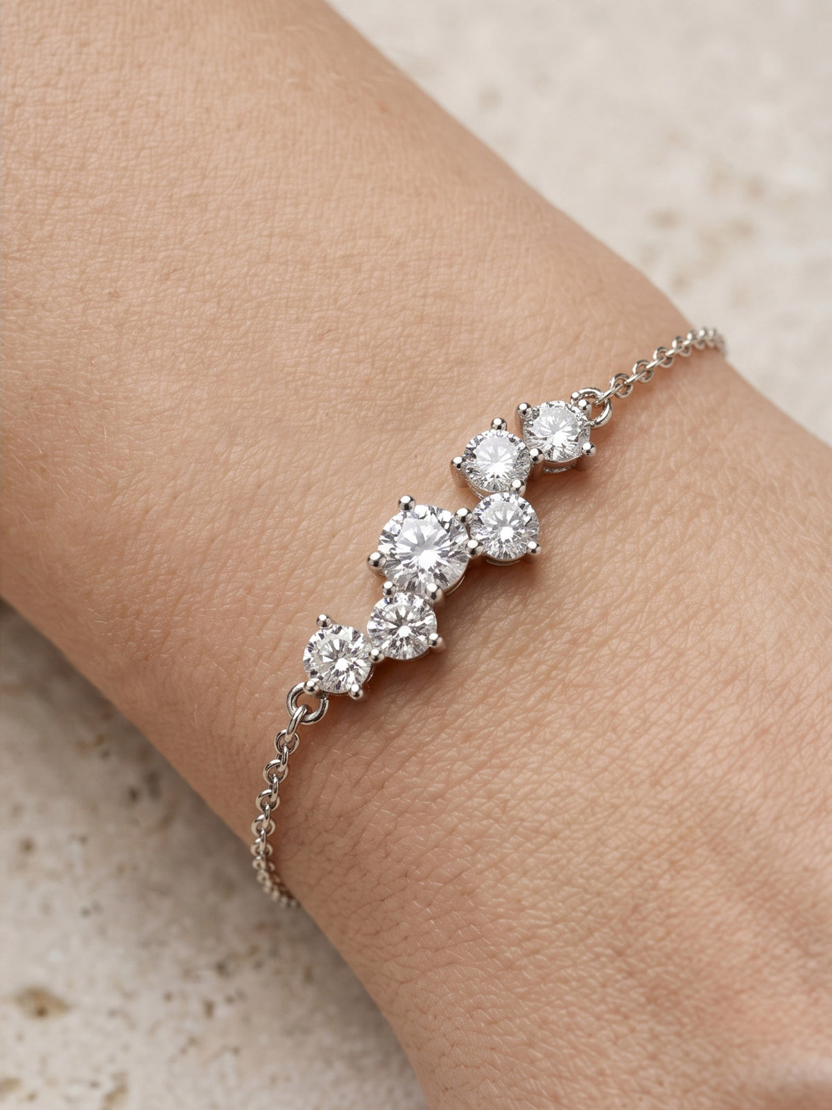 Close-up of a person's wrist wearing the silver CZ cluster chain bracelet, highlighting the sparkling stone setting against the skin.