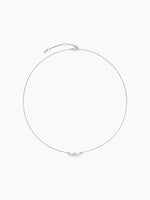 The silver CZ cluster chain necklace laid out in a perfect circle on a white background, highlighting the thin chain and central stones.