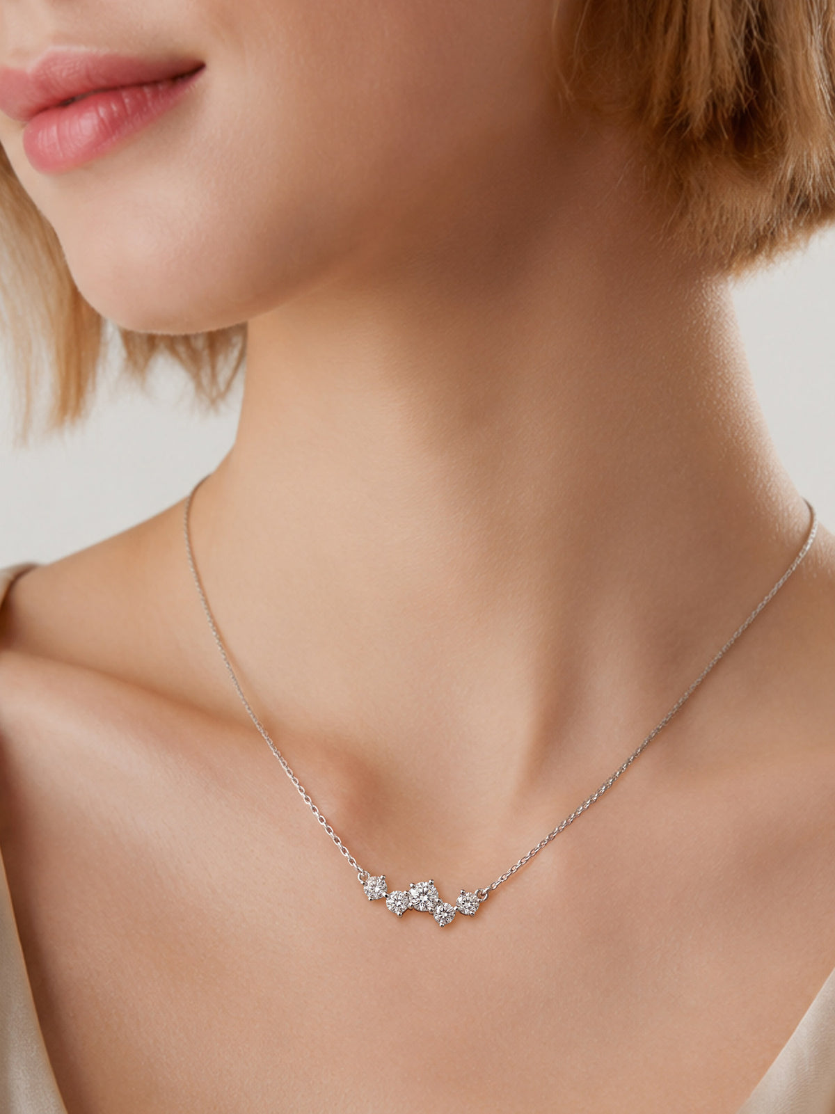 Woman wearing a dainty silver CZ cluster necklace on a fine cable chain. Elegant minimal jewelry for everyday wear.