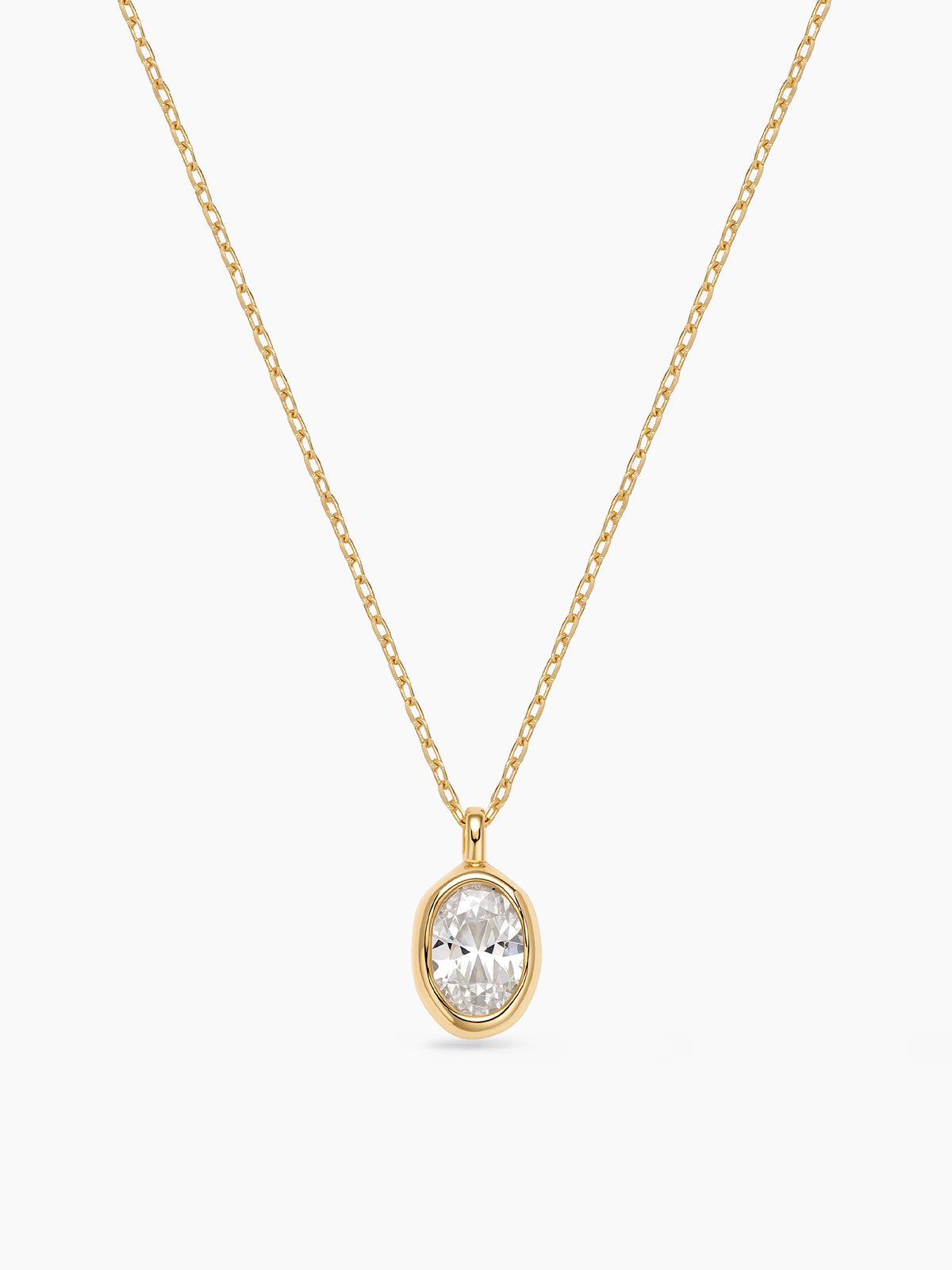 A delicate gold chain necklace featuring a bezel-set oval cubic zirconia pendant, displayed on a plain white background.