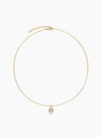 The gold oval CZ necklace laid out in a perfect circle on a white background, highlighting the thin chain and central pendant.