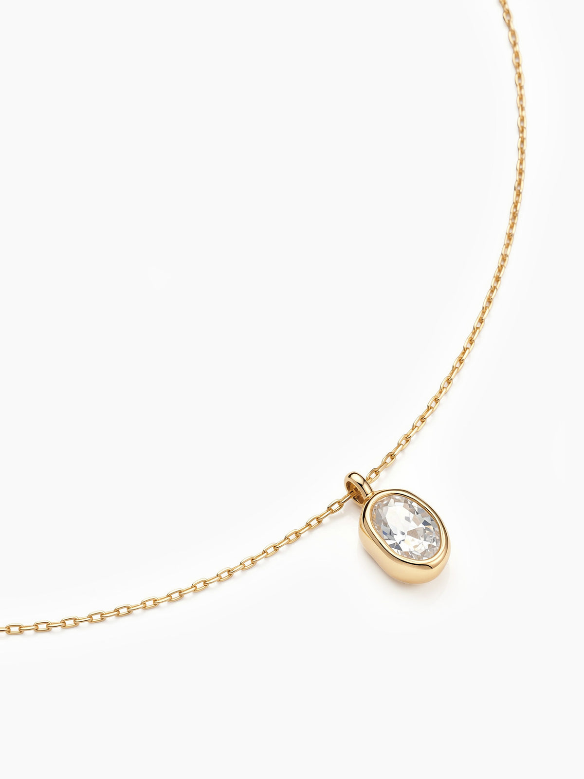 A close-up angled view of the oval cubic zirconia pendant on its gold chain, focusing on the sparkling stone and bezel setting.