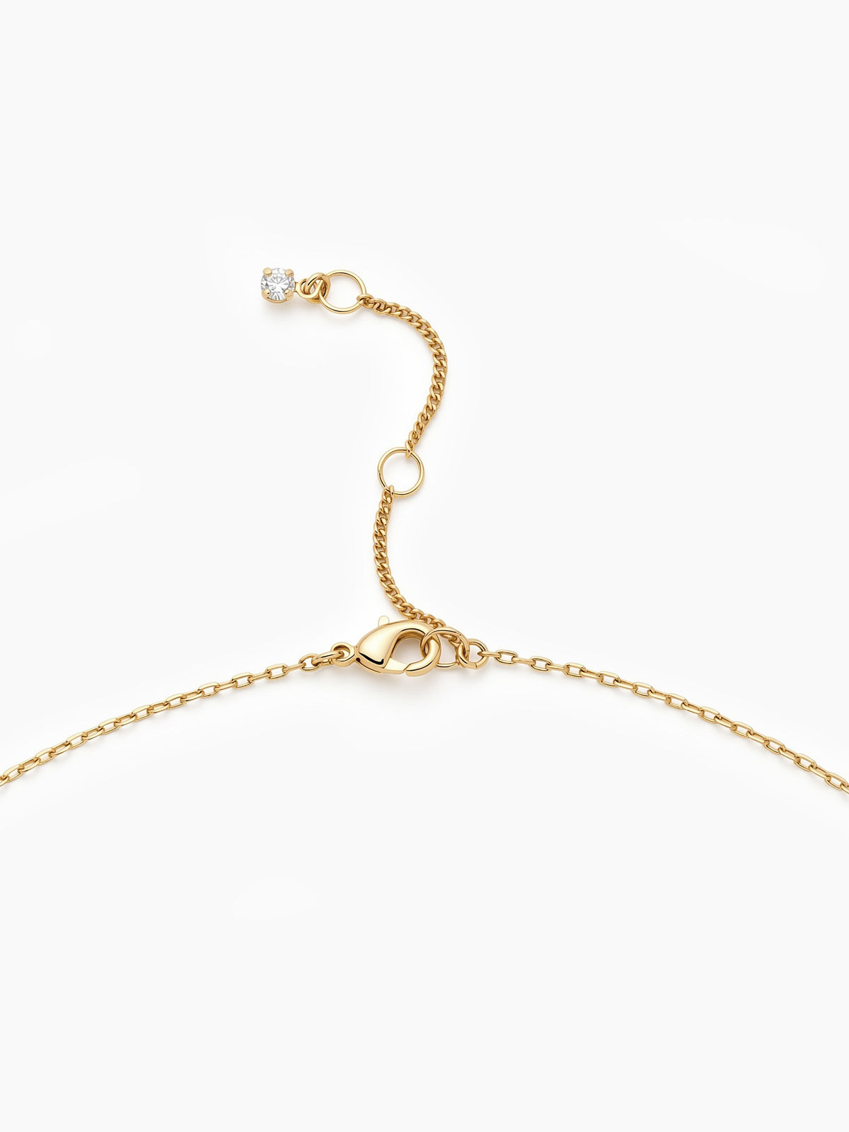 A close-up of the delicate gold chain showing the lobster clasp and an adjustable sliding bead.