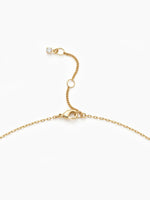 A close-up of the delicate gold chain showing the lobster clasp and an adjustable sliding bead.