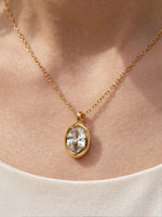 Close-up of a model's neckline wearing the gold oval CZ pendant necklace, showcasing its sleek and elegant look against the skin.